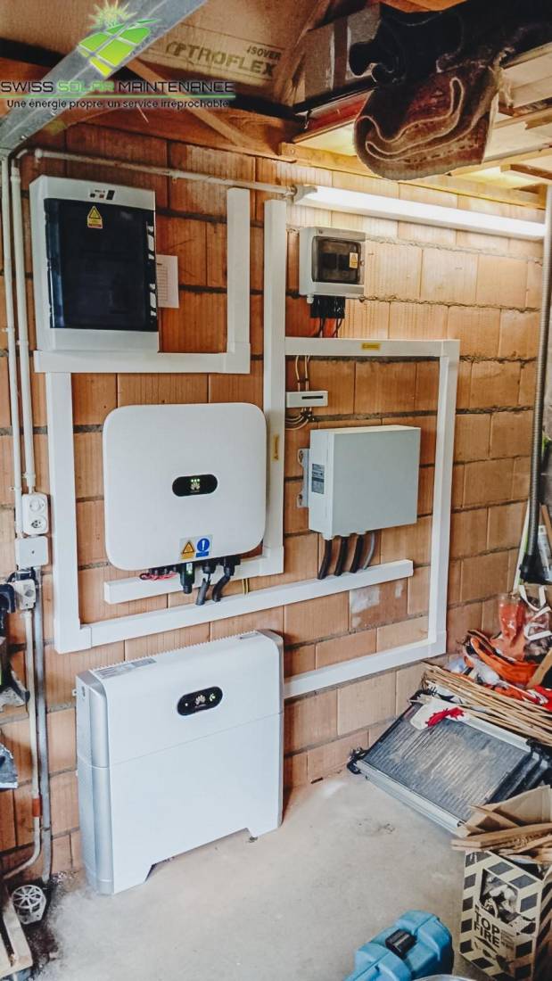 Onduleur et batterie de stockage solaire installés dans un local technique à Genève
