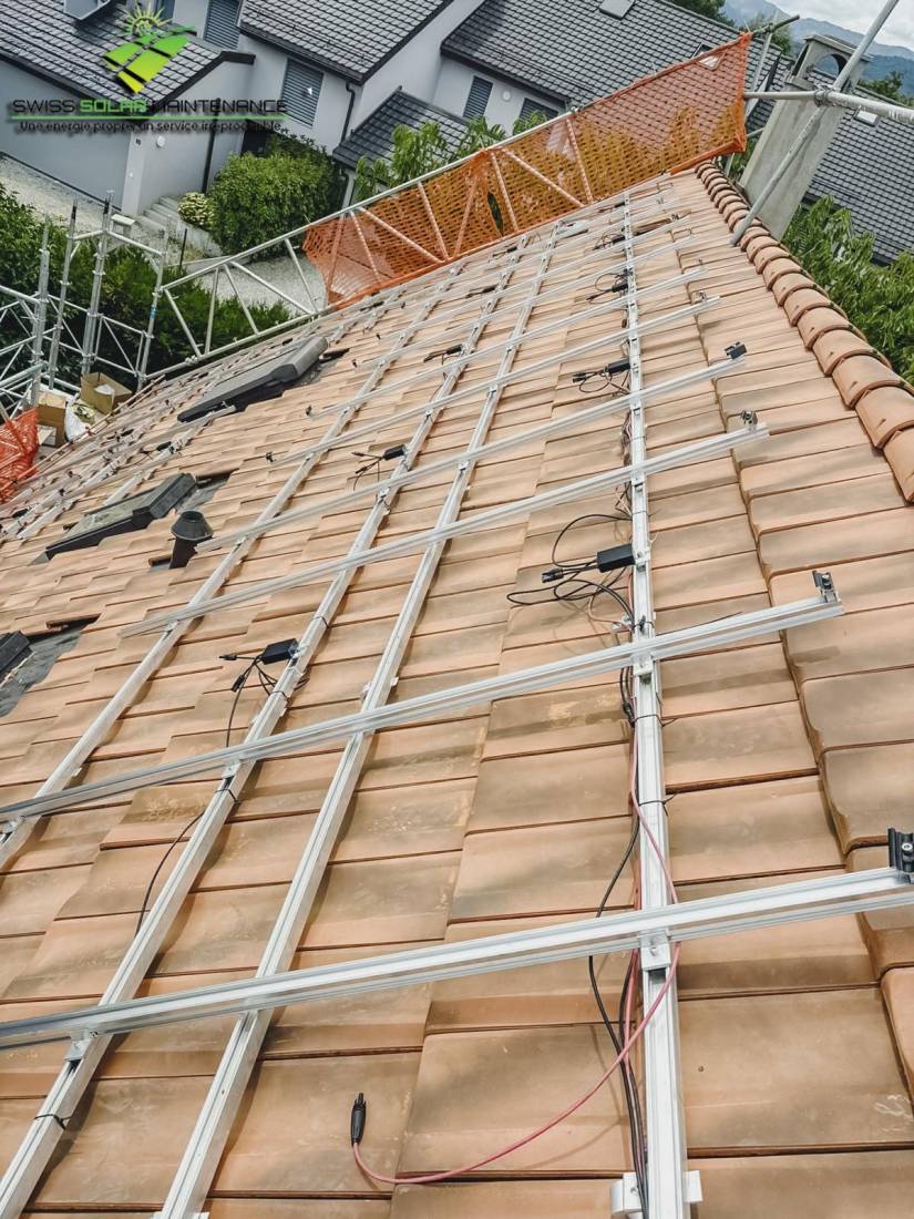 Pose des rails de fixation sur une toiture en tuiles lors d'un chantier photovoltaïque
